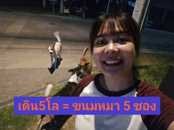 ภาพหน้าปกคลิป ฝ้ายเซลฟี่ยิ้มกว้างยามค่ำ มีสุนัขเดินอยู่ด้านหลัง พร้อมข้อความ เดิน5โล = ขนมหมา 5 ซอง จากผลงาน ID 057